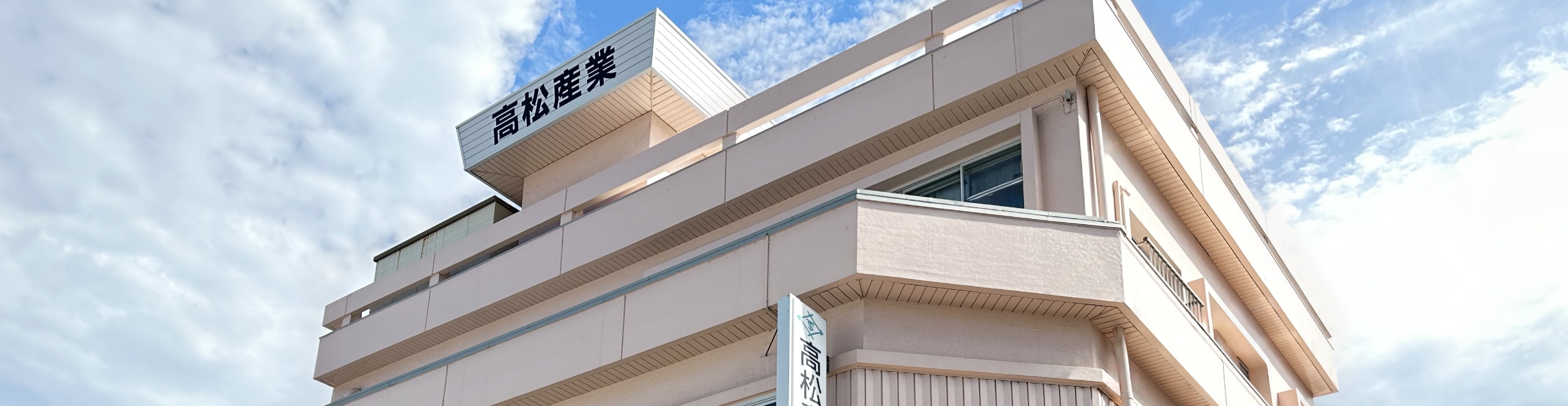 高松産業の社屋と青空