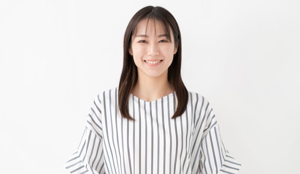 ボーダーの服を着た若い女性が微笑んでいる様子