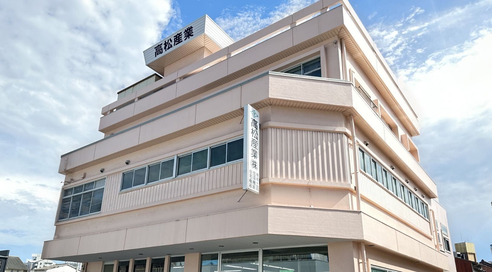 高松産業の社屋外観と青空